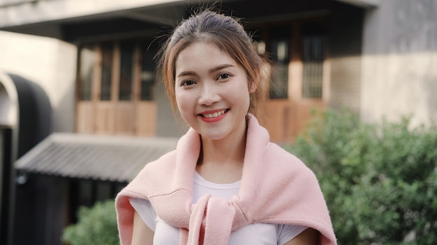 Mujer asiática joven hermosa alegre que siente la sonrisa feliz a la cámara mientras que viaja en Chinatown en Pekín, China.