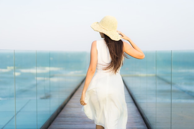 Mujer asiática joven hermosa del retrato feliz y sonrisa en el mar y el océano de la playa