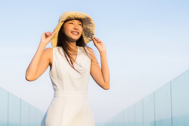 Mujer asiática joven hermosa del retrato feliz y sonrisa en el mar y el océano de la playa