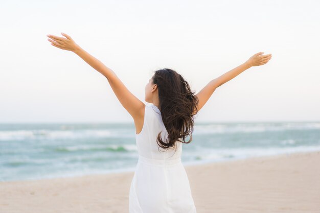 Mujer asiática joven hermosa del retrato feliz y sonrisa en el mar y el océano de la playa