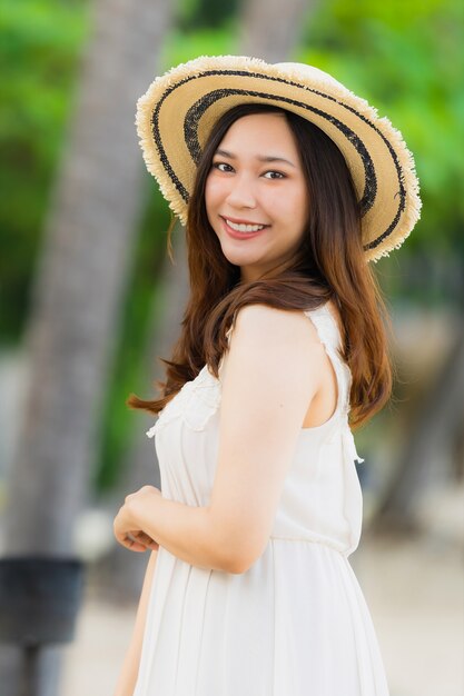 Mujer asiática joven hermosa del retrato feliz y sonrisa en el mar y el océano de la playa