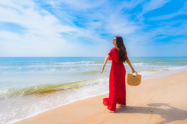 Mujer asiática joven hermosa del retrato en la playa y el mar