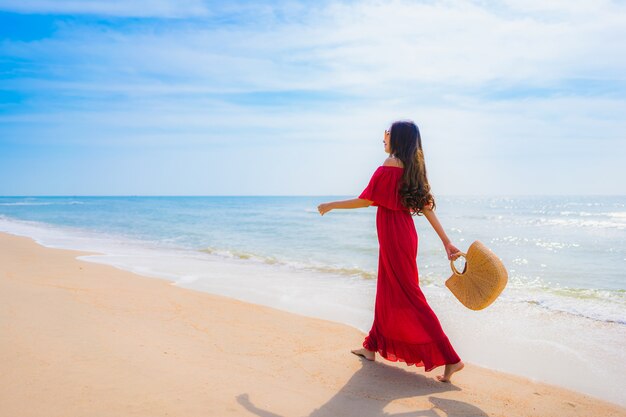 Mujer asiática joven hermosa del retrato en la playa y el mar