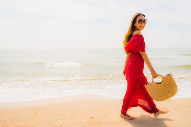 Mujer asiática joven hermosa del retrato en la playa y el mar