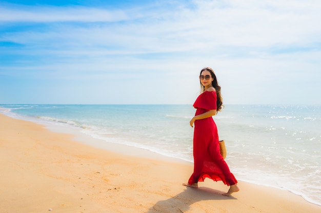 Mujer asiática joven hermosa del retrato en la playa y el mar