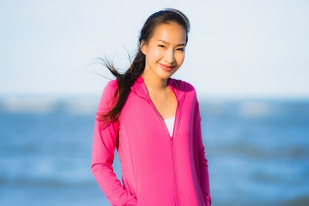 Foto gratuita mujer asiática joven hermosa del retrato que corre o ejercita en el paisaje de la naturaleza del tropica de la playa