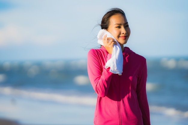 Mujer asiática joven hermosa del retrato que corre o ejercita en el paisaje de la naturaleza del tropica de la playa