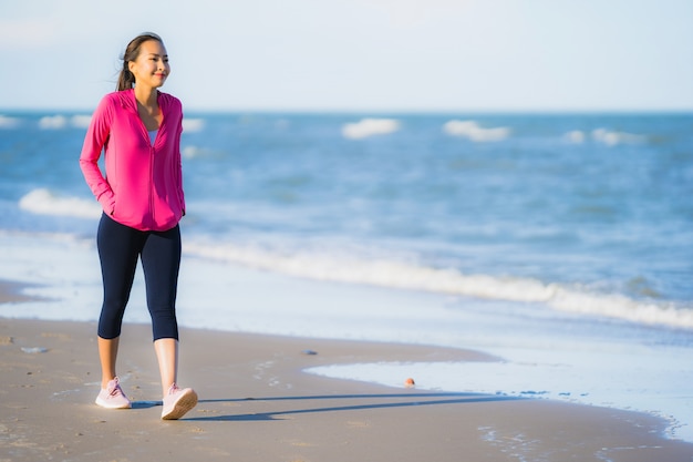 Mujer asiática joven hermosa del retrato que corre o ejercita en el paisaje de la naturaleza del tropica de la playa