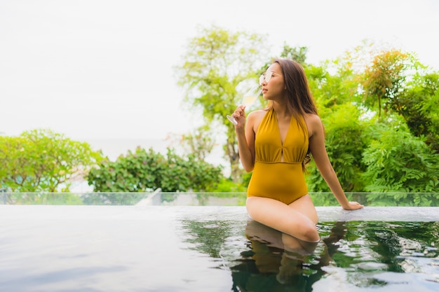 Foto gratuita la mujer asiática joven hermosa del retrato con el vidrio del champán para relaja el ocio