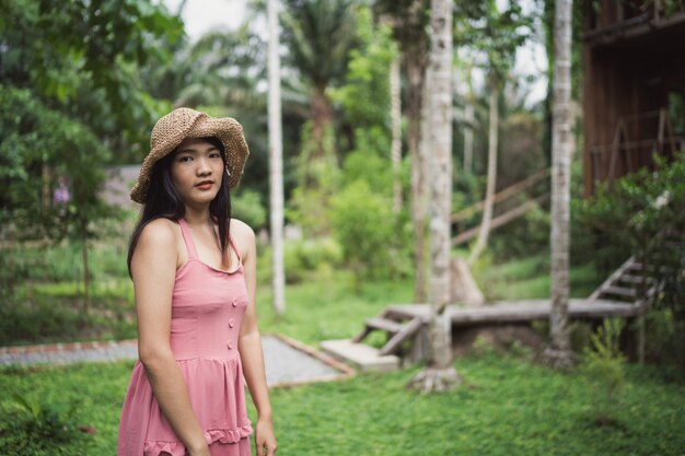 La mujer asiática joven se relaja en el bosque, el utilizar femenino hermoso feliz relaja tiempo en naturaleza.