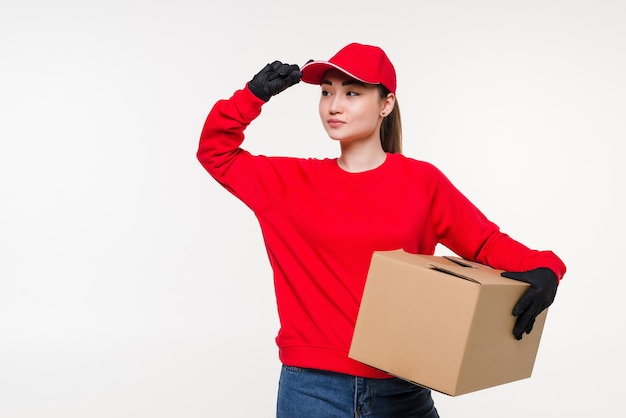 Mujer asiática joven con trabajador de servicio de entrega en uniforme. Caja de explotación de mujer con atractiva sonrisa aislada.