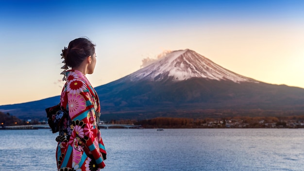 Mujer asiática con kimono tradicional japonés en la montaña Fuji. Puesta de sol en el lago Kawaguchiko en Japón.