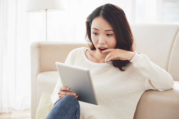 Mujer asiática leyendo noticias emocionantes