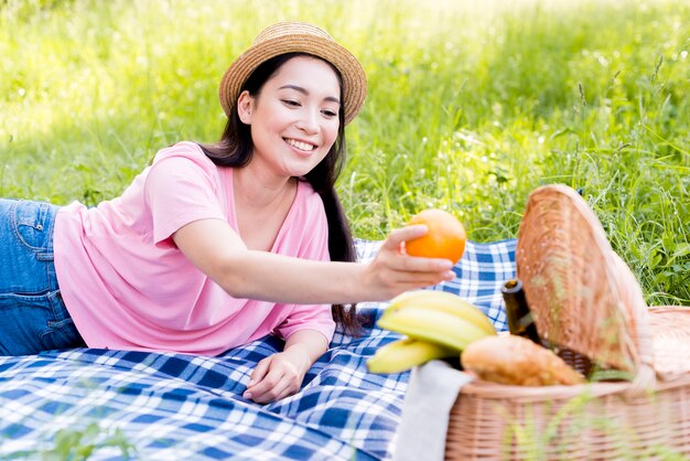 Mujer asiática con naranja en la mano