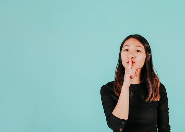 Mujer asiática pidiendo mantener en secreto