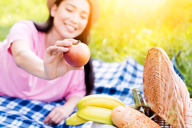 Mujer asiática que sostiene la manzana en la mano