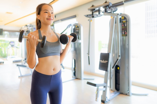 La mujer asiática del retrato que ejercita y se resuelve en gimnasio