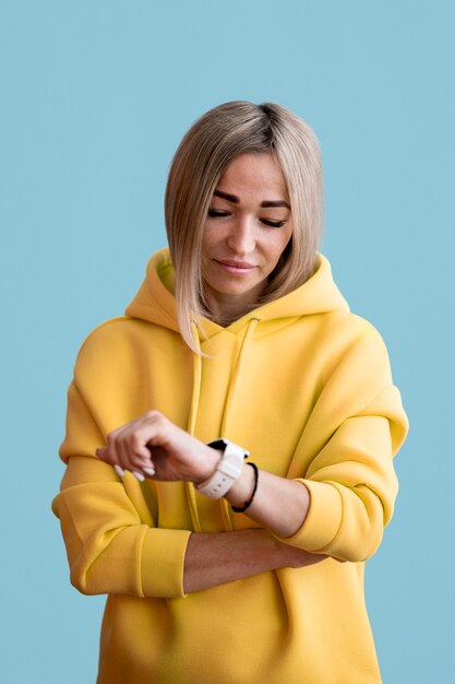 Mujer asiática rubia mirando su reloj inteligente