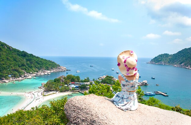 Mujer asiática sentada en la piedra en punto de vista asombroso en la isla de Nangyuan.