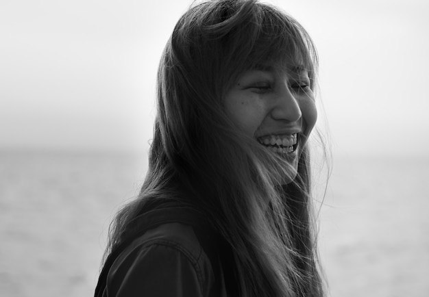 Mujer asiática sonriendo con ojos cerrados retrato