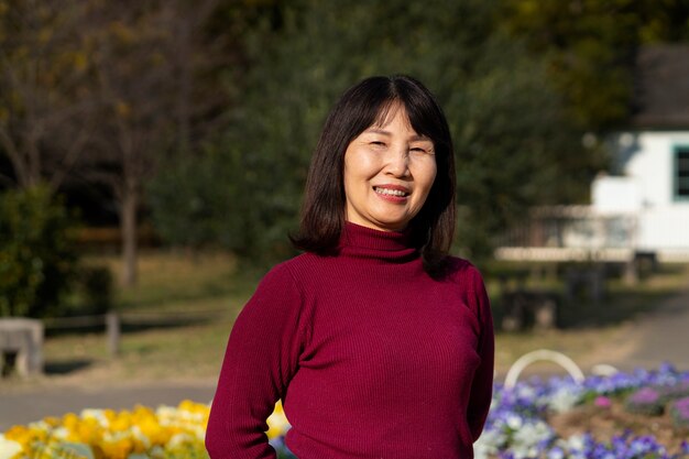 Mujer asiática sonriente al aire libre tiro medio