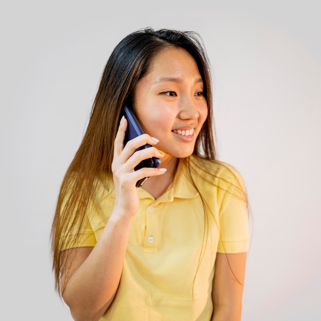 Mujer asiática sonriente hablando por teléfono