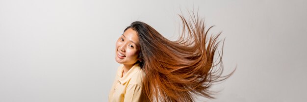 Mujer asiática sonriente que tiene el pelo largo