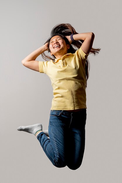 Mujer asiática sonriente saltando