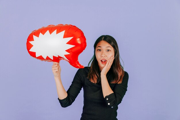 Mujer asiática sorprendida con globo de discurso