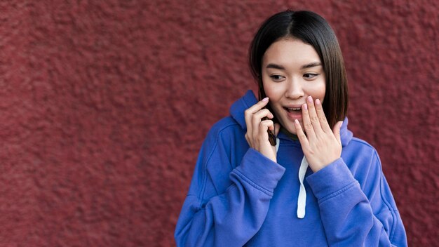 Foto gratuita mujer asiática sorprendida hablando por teléfono