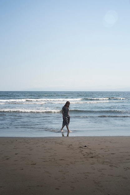 Mujer asiática de tiro largo en la playa