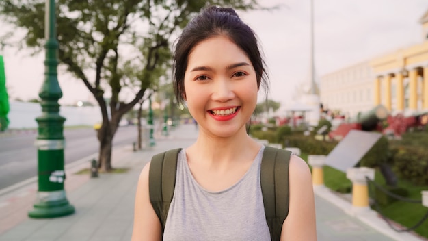 Mujer asiática del viajero que se siente feliz sonriendo al viaje de vacaciones de la cámara en Bangkok, Tailandia