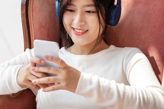 Mujer asiática viendo un videoclip desde el teléfono