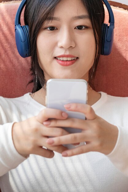 Mujer asiática viendo un videoclip desde el teléfono