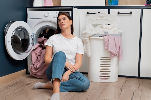 Mujer con aspecto cansado después de lavar la ropa