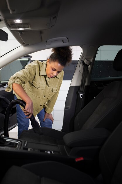 Mujer aspirando los asientos del auto