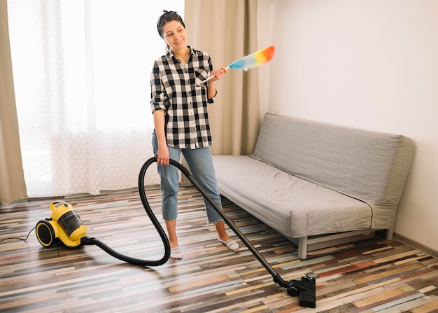 Mujer aspirando en la sala de estar