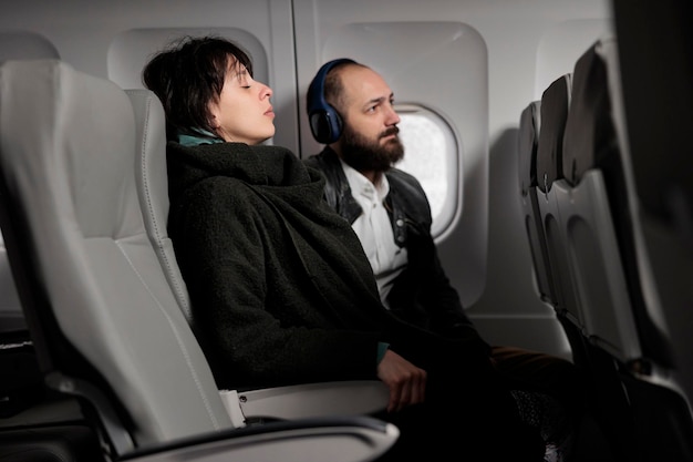 Mujer asustada esperando que el avión despegue y vuele al extranjero, sintiéndose asustada por la salida aérea en avión. Viajar en avión en vuelo comercial para ir de vacaciones.