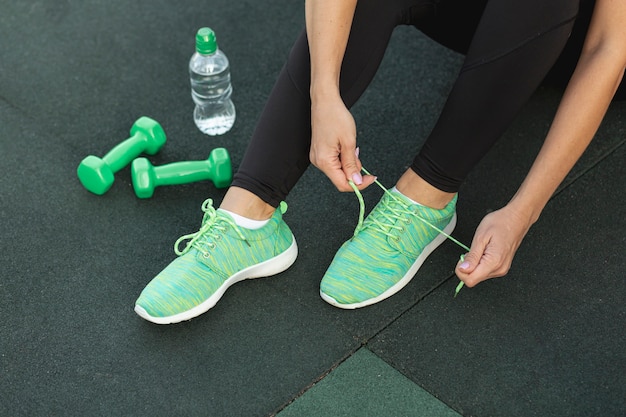 Mujer atando sus zapatillas verdes