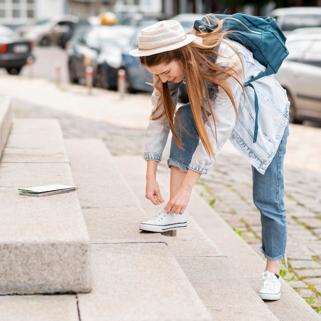 Foto gratuita mujer atando sus zapatos en las escaleras