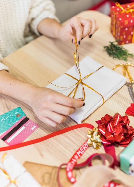 Foto gratuita mujer atar arco en caja de regalo pequeña