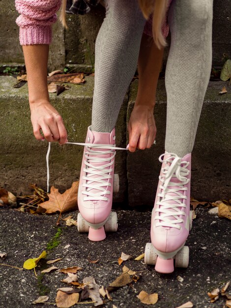 Mujer atar cordones de los zapatos en patines