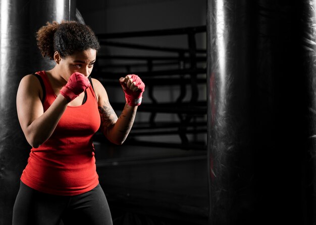 Mujer atlética entrenando sola en el centro de boxeo