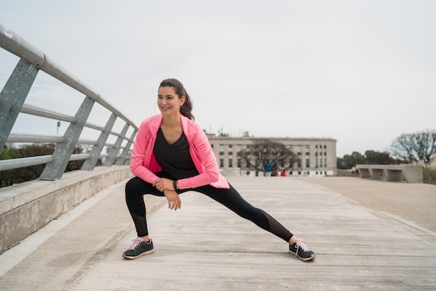 Mujer atlética estirando las piernas antes del ejercicio