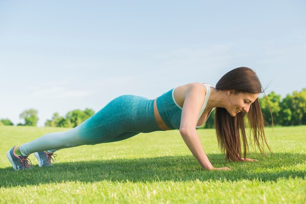 Mujer atlética practicando yoga al aire libre