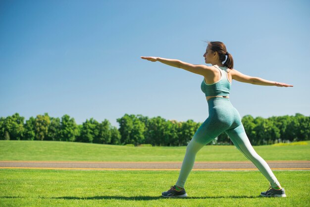 Mujer atlética practicando yoga al aire libre