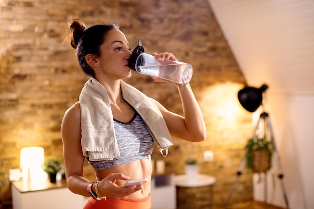 Foto gratuita mujer atlética que se rompe agua mientras hace ejercicio en casa
