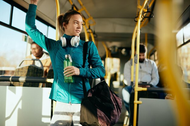 Mujer atlética que viaja al entrenamiento deportivo en autobús