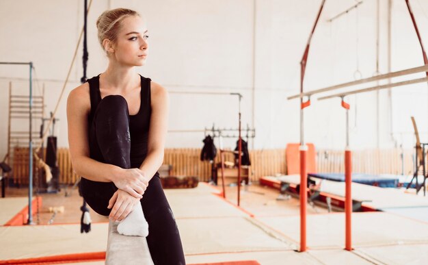 Mujer atlética relajante después del entrenamiento de gimnasia con espacio de copia