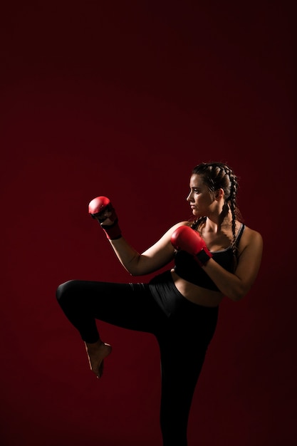 Mujer atlética en ropa de fitness sobre fondo rojo